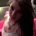Person sitting on a red chair with a necklace